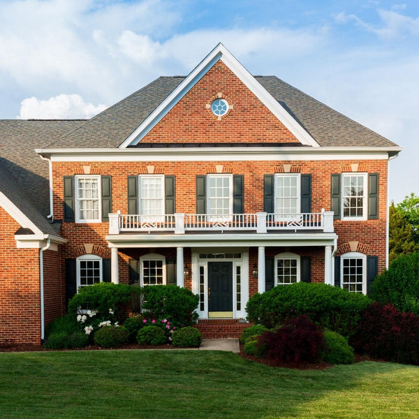 brick house with shutters and black door